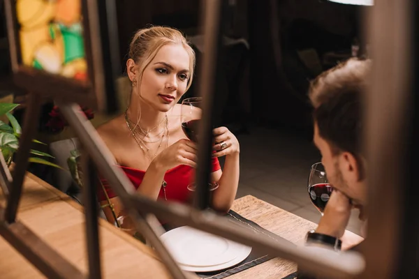 Mulher atraente olhando para o homem e flertando no restaurante — Fotografia de Stock