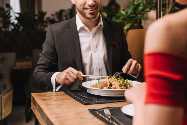 Recortado vista de hombre cenando con novia en restaurante - foto de stock