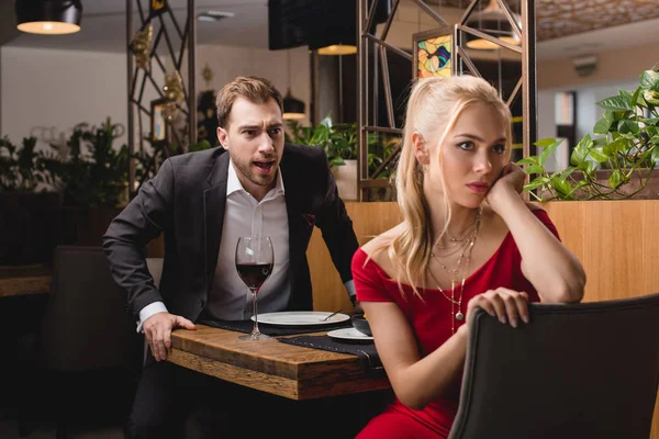 Selective focus of boyfriend screaming at offended woman in restaurant — Stock Photo