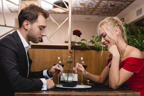 Happy couple sharing dessert while sitting in restaurant — Stock Photo