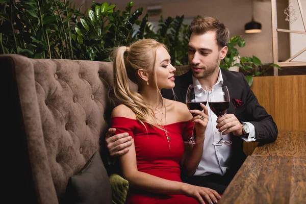 Attractive woman toasting with glass of red wine with boyfriend in restaurant — Stock Photo