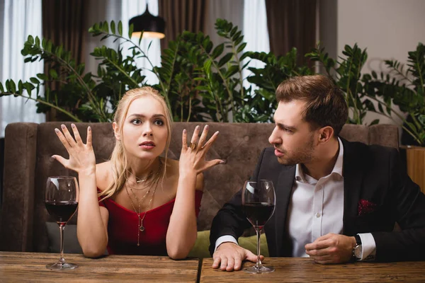 Mujer sorprendida gesto cerca de novio en el restaurante - foto de stock