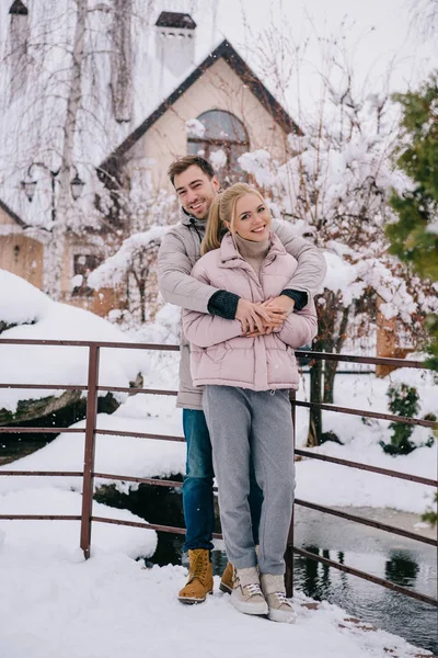Felice uomo abbracciare bionda attraente fidanzata in inverno — Foto stock