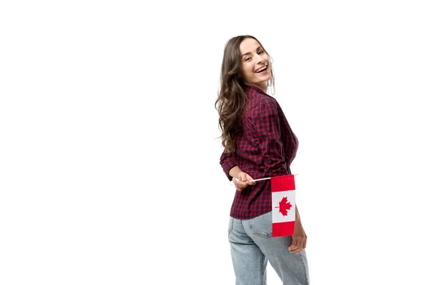 Atractiva mujer sonriente sosteniendo bandera canadiense aislada en blanco - foto de stock