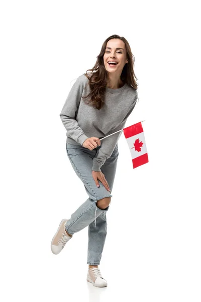 Mujer excitada en ropa casual gris sosteniendo bandera canadiense y mirando a la cámara aislada en blanco - foto de stock