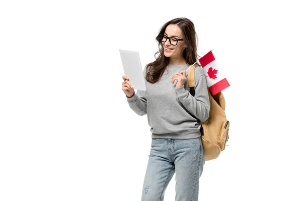Étudiante souriante dans des lunettes portant le drapeau canadien et utilisant une tablette numérique isolée sur du blanc — Photo de stock