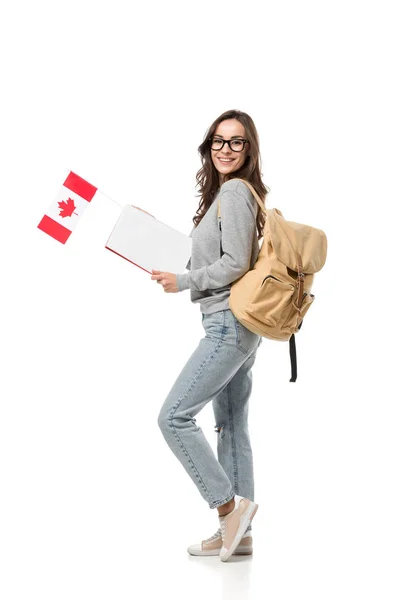 Estudiante femenina con mochila con bandera canadiense y cuaderno aislado en blanco - foto de stock