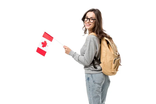 Estudiante femenina con bandera canadiense y mochila mirando a la cámara aislada en blanco - foto de stock