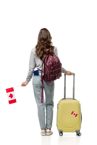 Обратный вид студентки с чемоданом и канадским флагом, изолированным на белом, изучающей зарубежную концепцию — стоковое фото