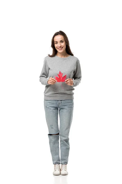 Beautiful woman in casual clothes looking at camera and holding maple leaf isolated on white — Stock Photo