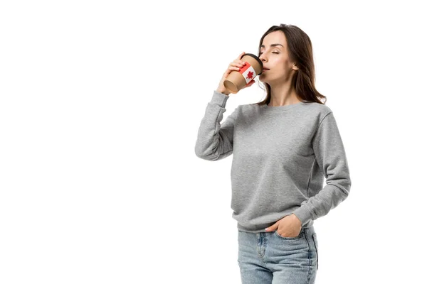 Frau trinkt Kaffee aus Tasse mit kanadischer Flagge Aufkleber isoliert auf weiß — Stockfoto