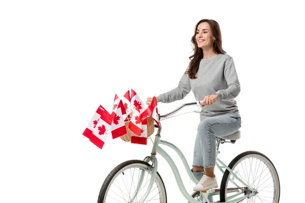 Smiling woman riding vintage bicycle with canadian flags isolated on white — Stock Photo