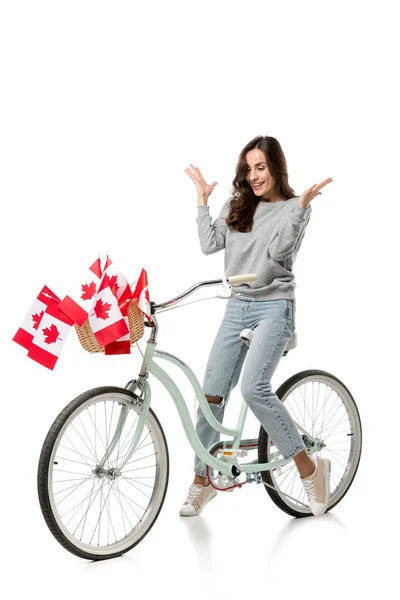 Жінка жестикулює руками і їде вінтажний велосипед з канадськими прапорами ізольовані на білому — стокове фото