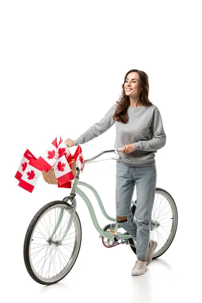 Hermosa mujer con bicicleta vintage y banderas canadienses aisladas en blanco - foto de stock