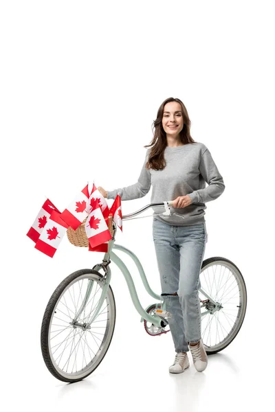 Красива усміхнена жінка з вінтажним велосипедом і канадськими прапорами ізольована на білому — стокове фото