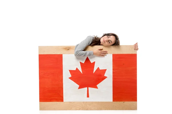 Frau mit geschlossenen Augen hält Holzbrett mit kanadischer Flagge isoliert auf weiß — Stockfoto