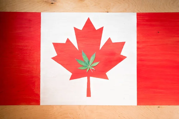 Hoja de cannabis en bandera canadiense, concepto de legalización de la marihuana - foto de stock