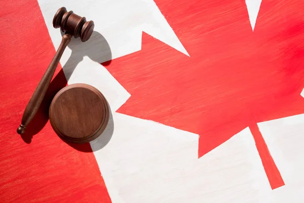 Mazo de madera con bandera canadiense sobre fondo, concepto de justicia - foto de stock