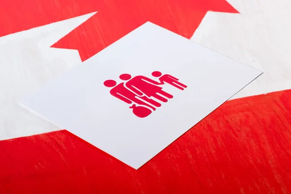 Selective focus of white card with family icon on canadian flag, immigration concept — Stock Photo