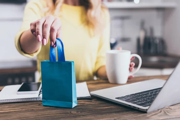 Selective focus of toy shopping bag in hands of woman holding cup — Stock Photo