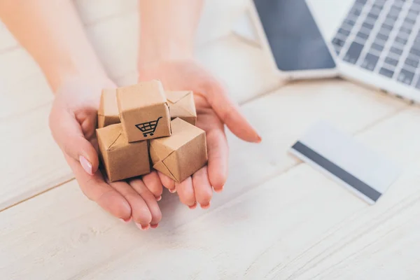 Vista recortada de la mujer sosteniendo pequeñas cajas de papel en las manos - foto de stock