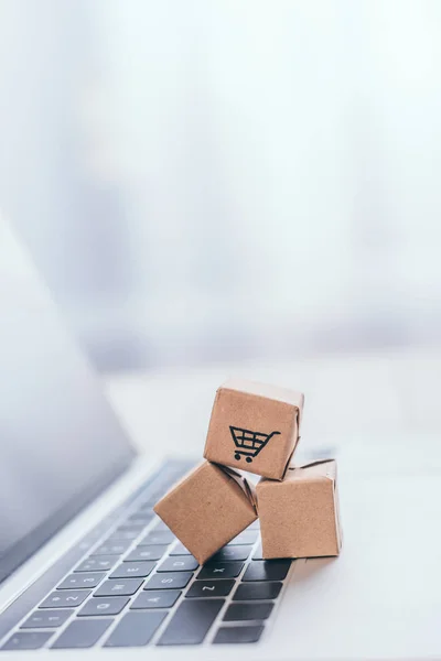 Close up of toy paper boxes on modern laptop keyboard — Stock Photo