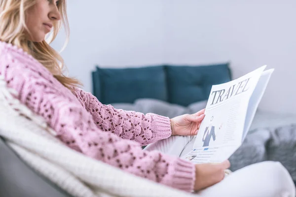 Обрезанный вид женщины, читающей дома туристическую газету — стоковое фото