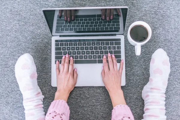 Draufsicht auf Bloggerin tippt auf Laptop-Tastatur in der Nähe Tasse Kaffee — Stockfoto