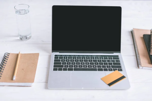 Notebooks e laptop com tela em branco e cartão de crédito na mesa de madeira — Fotografia de Stock