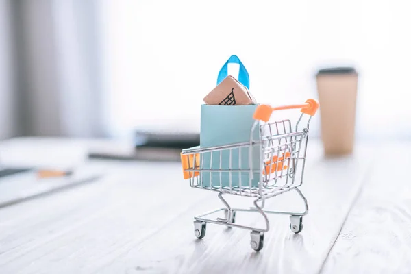 Selective focus of toy cart with shopping bag — Stock Photo