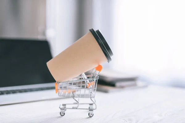 Foyer sélectif de tasse en papier dans le chariot de jouet sur le bureau en bois — Photo de stock