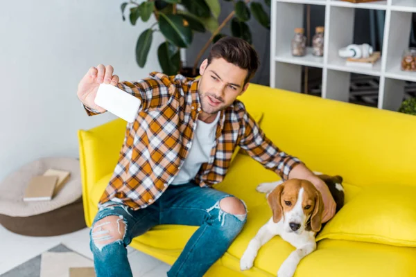 Happy man taking selfie on smartphone with cute dog — Stock Photo