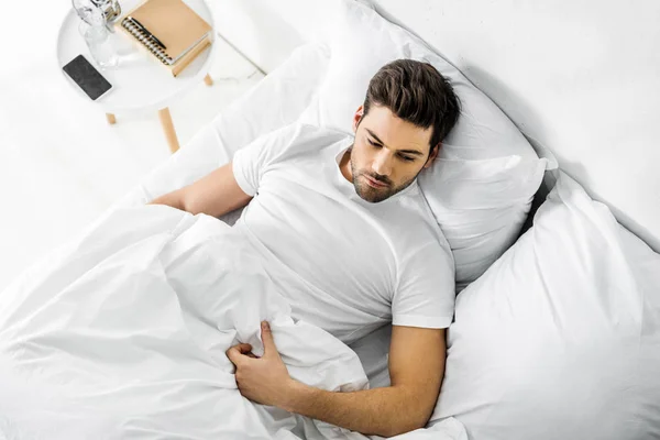 Top view of handsome man resting in bed in the morning — Stock Photo