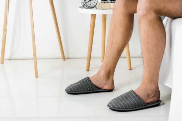 Обрезанный вид на мужские ноги в тапочках в спальне — Stock Photo