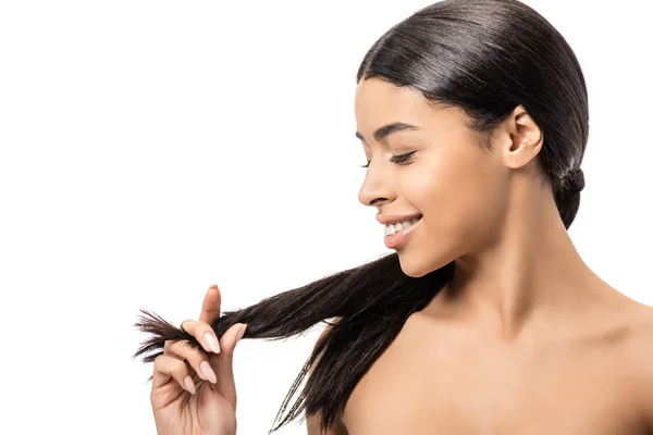 Привлекательный улыбающийся голый африканский американец девушка глядя на длинные волосы брюнетки изолированы на белом — стоковое фото