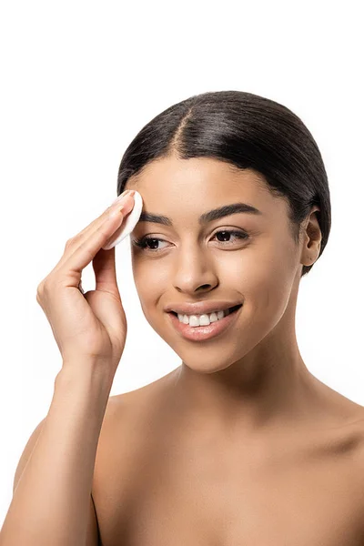 Felice giovane donna africana americana pulizia viso con disco di cotone isolato su bianco — Foto stock