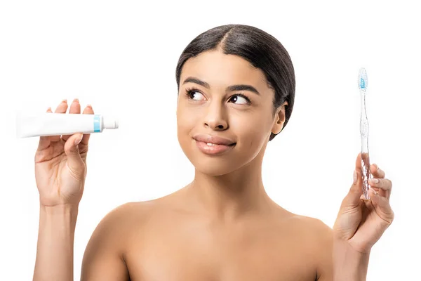 Smiling naked african american girl holding toothpaste and toothbrush isolated on white — Stock Photo