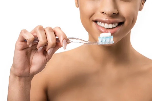 Обрізаний знімок щасливої молодої афроамериканки, що тримає зубну щітку з зубною пастою ізольовано на білому — стокове фото