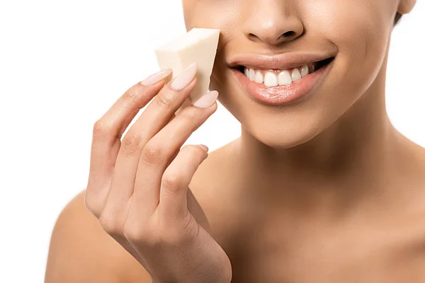 Gros plan vue partielle de la jeune femme afro-américaine souriante tenant une éponge de maquillage isolée sur blanc — Photo de stock
