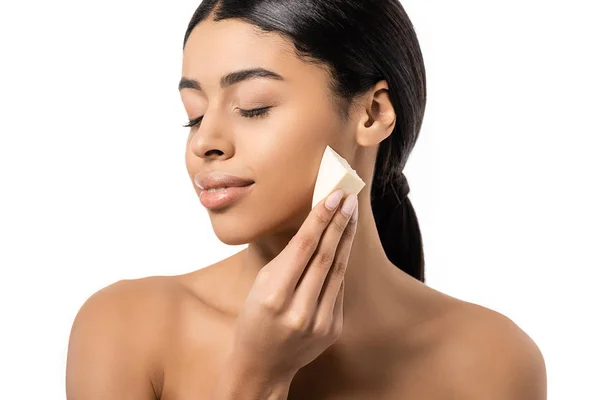 Beautiful naked african american girl with closed eyes holding makeup sponge isolated on white — Stock Photo