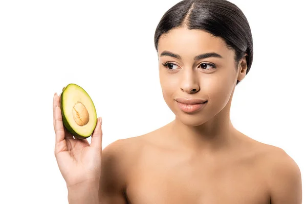 Schöne nackte afrikanisch-amerikanische Frau sieht die Hälfte der Avocado in der Hand isoliert auf weiß — Stockfoto