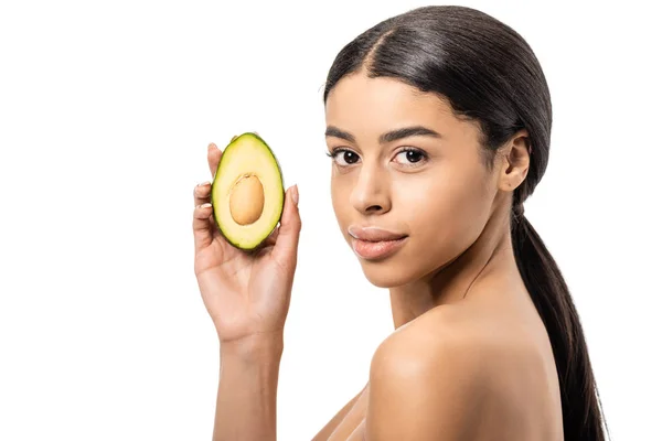 Приваблива гола афроамериканка тримає авокадо і дивиться на камеру ізольовано на білому — стокове фото