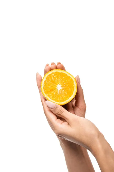 Primer plano vista parcial de la mujer afroamericana sosteniendo rebanada de naranja en manos aisladas en blanco - foto de stock