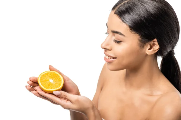 Vista de ángulo alto de sonriente joven afroamericana mujer sosteniendo la mitad de naranja aislado en blanco - foto de stock