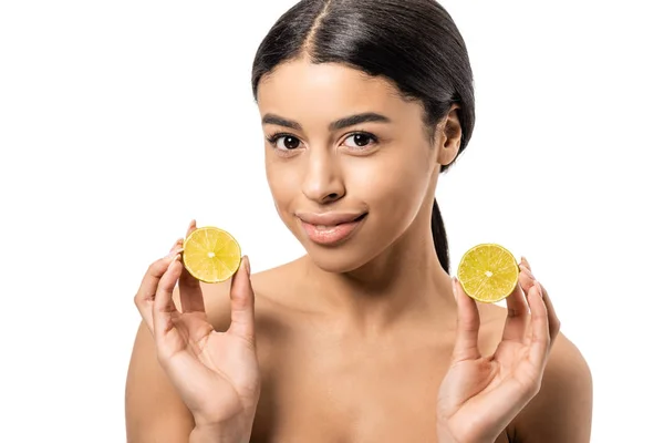 Attractive naked african american girl holding halves of lime and smiling at camera isolated on white — Stock Photo