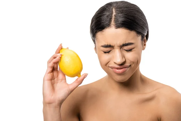 Junge nackte afrikanisch-amerikanische Frau mit geschlossenen Augen hält Zitrone und runzelt die Stirn isoliert auf weiß — Stockfoto