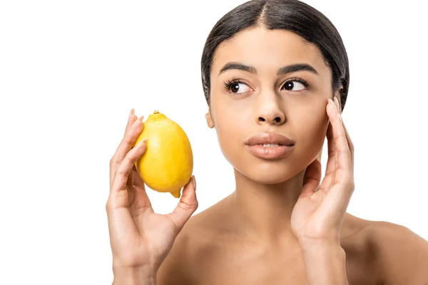 Привлекательная молодая африканская американка, держащая свежий лимон и трогательное лицо, изолированное на белом — стоковое фото