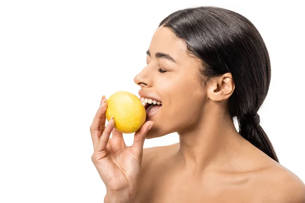 Smiling naked african american girl with closed eyes biting lemon isolated on white — Stock Photo