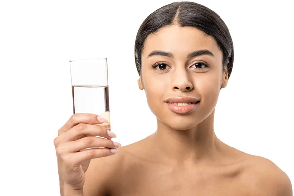 Красива гола афроамериканка тримає склянку води і посміхається на камеру ізольовано на білому — стокове фото