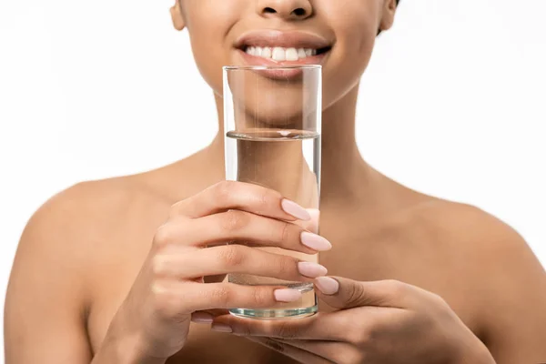 Plan recadré de fille afro-américaine nue heureuse tenant verre d'eau isolé sur blanc — Photo de stock